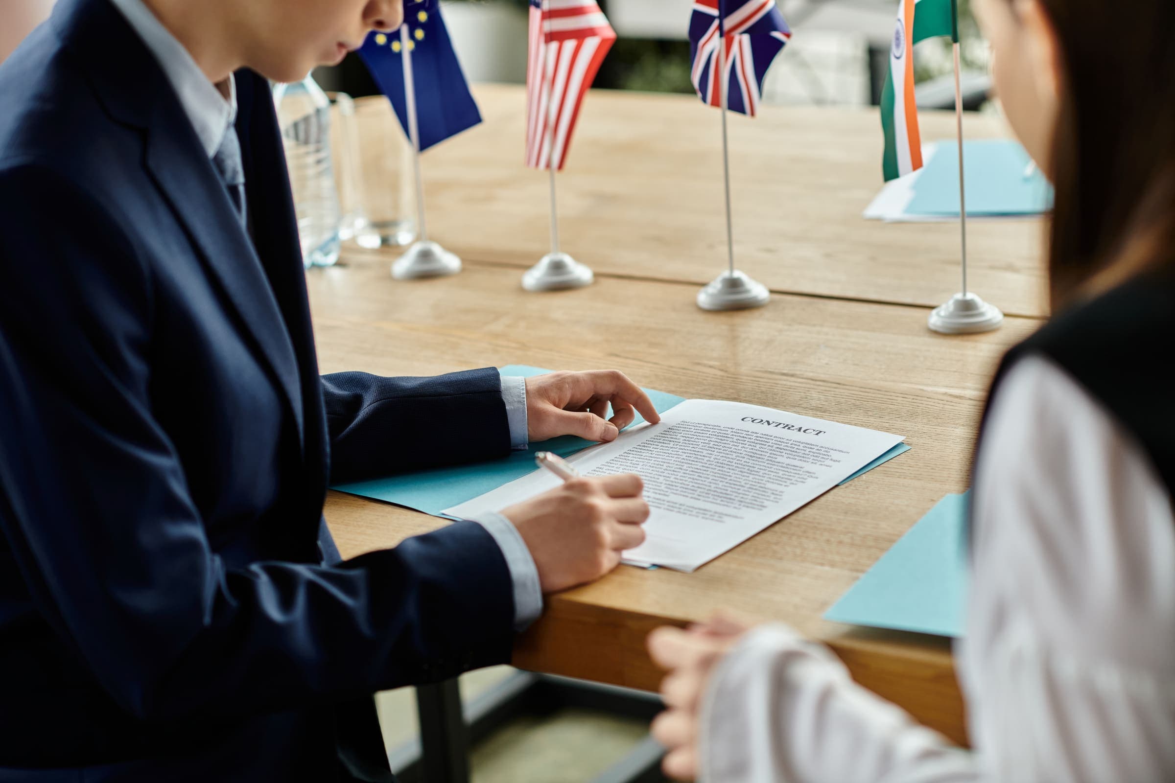 Business professionals signing a contract at an international meeting