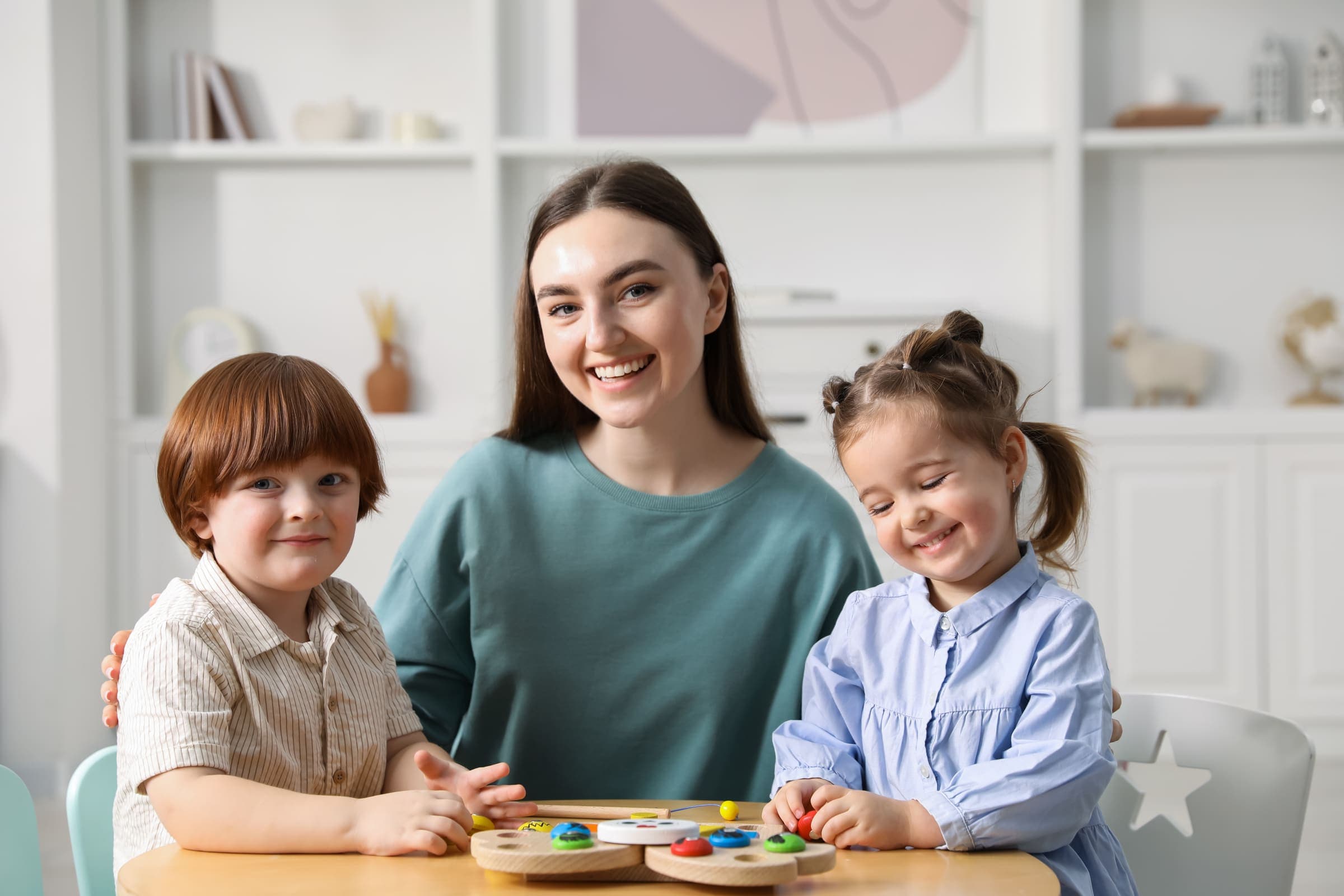 Early childhood educator playing with children using wooden learning toys