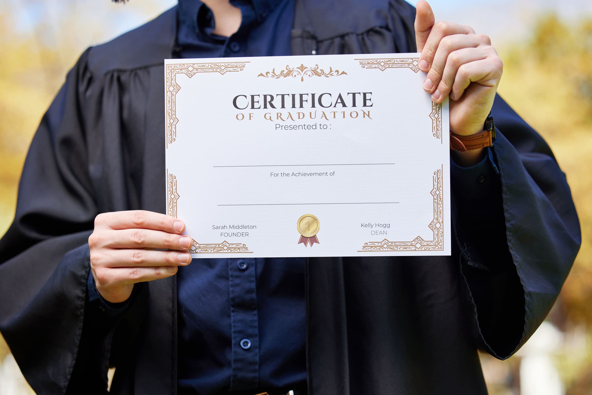 Graduate holding a certificate of graduation outdoors